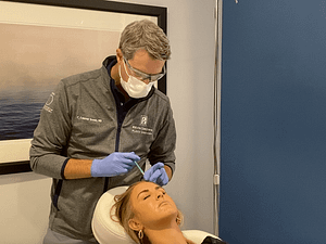 Dr. Brown injecting botox to the forehead on a young woman