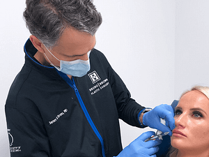 Dr. Bruno injecting filler into lip of young woman